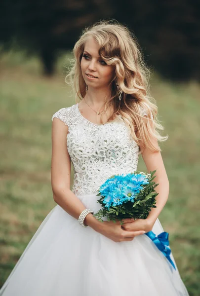 Роскошный портрет белокурой невесты с свадебным букетом осенью — стоковое фото