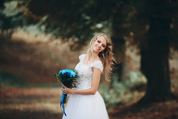 Роскошный портрет белокурой невесты с свадебным букетом осенью — стоковое фото