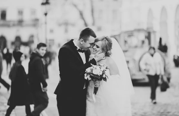 Hochzeitspaar steht und küsst sich in den Straßen der Altstadt — Stockfoto