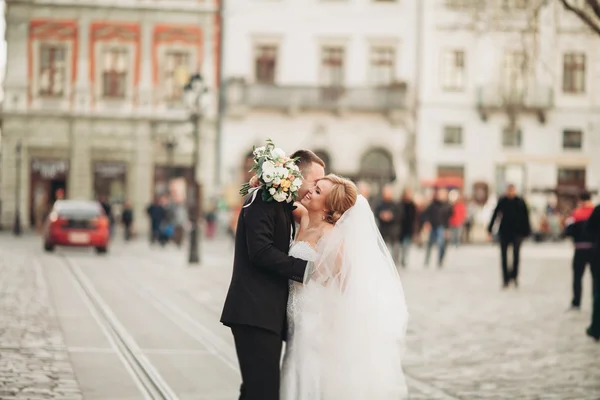 Wedding couple is standing and kissing in the streets of old city — Stock Photo, Image