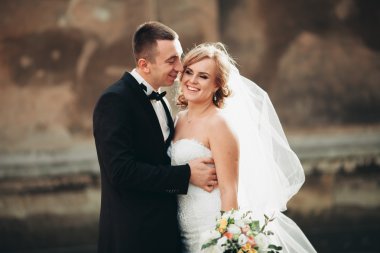 mutlu lüks düğün çift ayakta ve eski şehrin sokaklarında öpüşme olduğunu