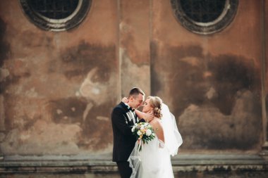 mutlu lüks düğün çift ayakta ve eski şehrin sokaklarında öpüşme olduğunu