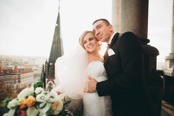 Elegante hermosa pareja de boda besándose y abrazándose en el fondo vista panorámica del casco antiguo — Foto de Stock