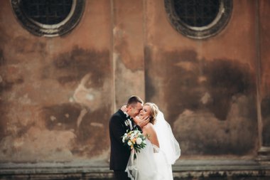 mutlu lüks düğün çift ayakta ve eski şehrin sokaklarında öpüşme olduğunu