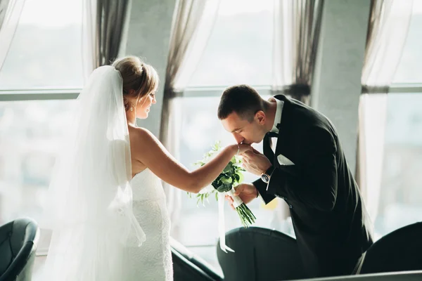 Casamento casal está de pé e beijando no hotel — Fotografia de Stock