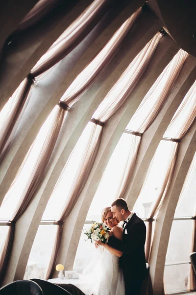 Hochzeitspaar steht und küsst sich im Hotel — Stockfoto