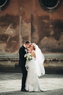 mutlu lüks düğün çift ayakta ve eski şehrin sokaklarında öpüşme olduğunu