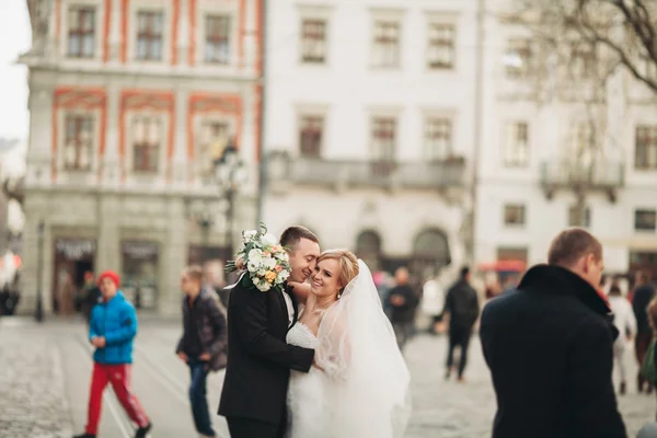 Hochzeitspaar steht und küsst sich in den Straßen der Altstadt — Stockfoto