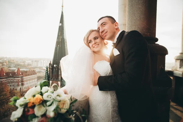 Elegante hermosa pareja de boda besándose y abrazándose en el fondo vista panorámica del casco antiguo — Foto de Stock