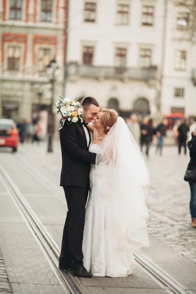 Wedding couple is standing and kissing in the streets of old city — Stock Photo, Image