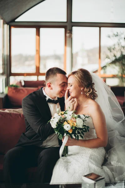 Wedding couple is standing and kissing in hotel — Stock Photo, Image