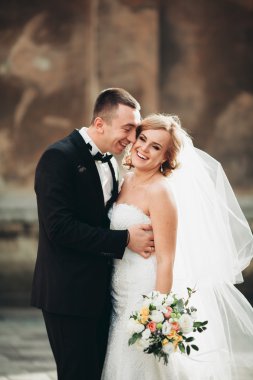 mutlu lüks düğün çift ayakta ve eski şehrin sokaklarında öpüşme olduğunu