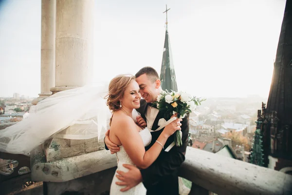 Stylový krásný svatební pár líbání a objímání na pozadí panoramatický výhled na staré město — Stock fotografie