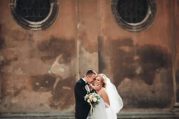 Glückliches Luxus-Hochzeitspaar steht und küsst sich in den Straßen der Altstadt — Stockfoto