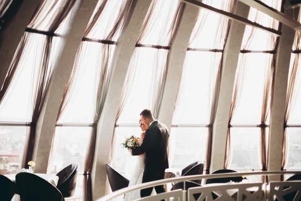 Wedding couple is standing and kissing in hotel — Stock Photo, Image