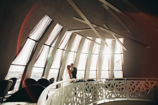 Wedding couple is standing and kissing in hotel — Stock Photo, Image