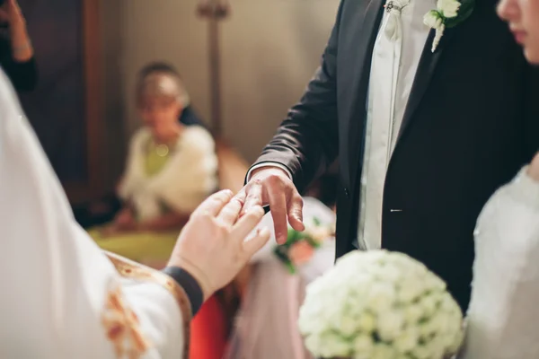 Recién casados vestido anillo de bodas en la iglesia —  Fotos de Stock