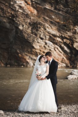 Yakışıklı romantik damat ve güzel gelin Nehri manzaralı dağlarında yakınında poz