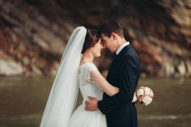 Yakışıklı romantik damat ve güzel gelin Nehri manzaralı dağlarında yakınında poz