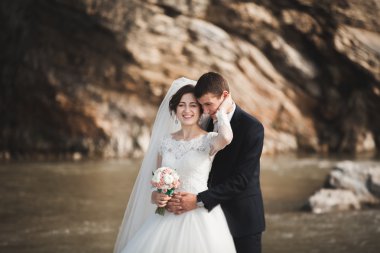 Yakışıklı romantik damat ve güzel gelin Nehri manzaralı dağlarında yakınında poz