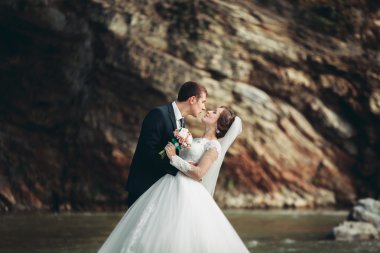 Yakışıklı romantik damat ve güzel gelin Nehri manzaralı dağlarında yakınında poz