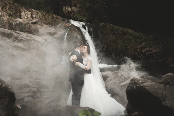 Beau couple de mariage séjour sur la pierre de la rivière dans les montagnes pittoresques — Photo