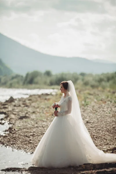 Dívka, model, nevěsta na pozadí řeky a hory. Portrét krása — Stock fotografie