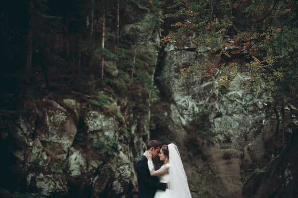 Casal bonito ficar na pedra do rio em montanhas cênicas — Fotografia de Stock