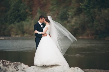 Yakışıklı romantik damat ve güzel gelin Nehri manzaralı dağlarında yakınında poz