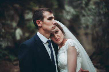 Güzel düğün çifti Nehri manzaralı dağlarda taş kalmak