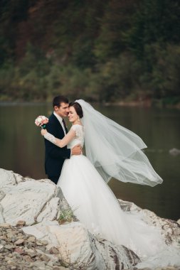Yakışıklı romantik damat ve güzel gelin Nehri manzaralı dağlarında yakınında poz