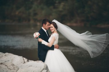 Yakışıklı romantik damat ve güzel gelin Nehri manzaralı dağlarında yakınında poz