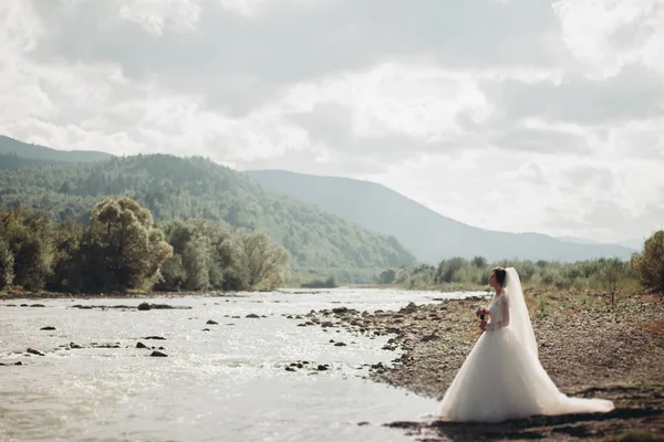 Chica, modelo, novia en un fondo del río y las montañas. Retrato de belleza —  Fotos de Stock