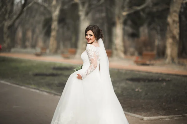 Krásná nevěsta v parku na její svatební den s kyticí — Stock fotografie