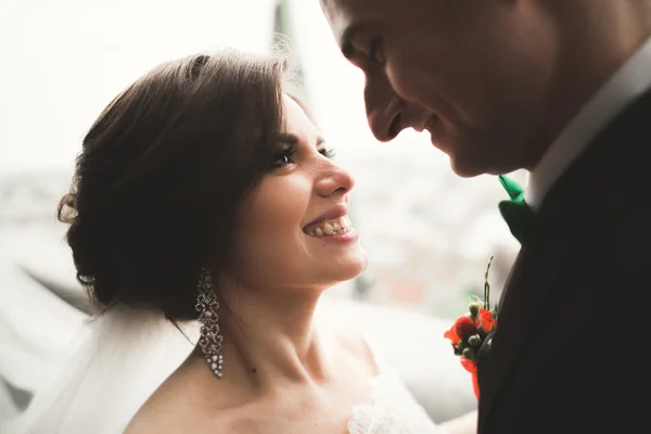 Hermosa pareja de recién casados de pie en el balcón con una vista de la ciudad — Foto de Stock