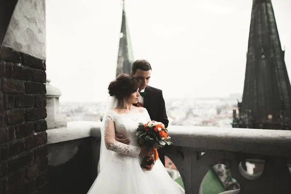 Schönes Brautpaar steht auf Balkon mit Blick auf die Stadt — Stockfoto