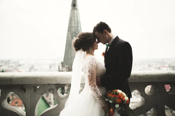 Gyönyörű esküvői pár ifjú állva erkély tartozik, kilátással a városra — Stock Fotó