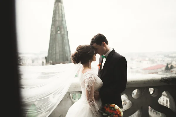 Casamento bonito casal recém-casados de pé na varanda com vista para a cidade — Fotografia de Stock