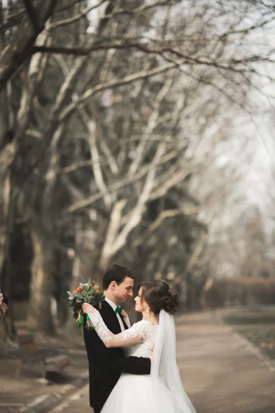 Casal de casamento feliz bonita andando no parque em seu dia com buquê — Fotografia de Stock