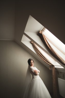 Beyaz elbiseli lüks gelin düğün törenine hazırlanırken poz veriyor.