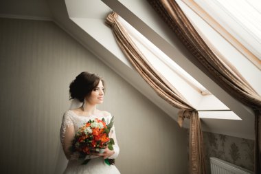 Beyaz elbiseli lüks gelin düğün törenine hazırlanırken poz veriyor.