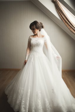 Beyaz elbiseli lüks gelin düğün törenine hazırlanırken poz veriyor.