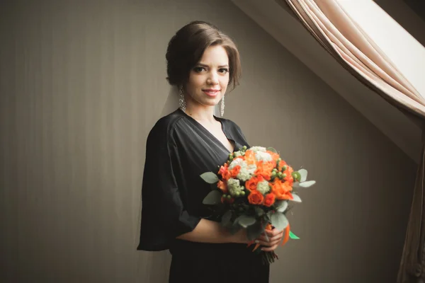 Noiva de luxo em roupão preto posando enquanto se prepara para a cerimônia de casamento — Fotografia de Stock