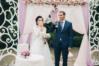 Çift ayakta taze çiçek bir kemerin altında düğün