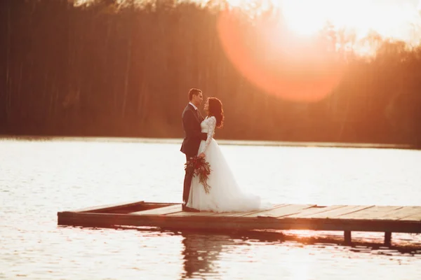 Para elegancki ślub piękny pozowanie w pobliżu Jezioro o zachodzie słońca — Zdjęcie stockowe