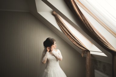 Beyaz elbiseli lüks gelin düğün törenine hazırlanırken poz veriyor.