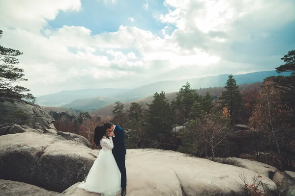 Linda noiva, noivo beijando e abraçando perto das falésias com vistas deslumbrantes — Fotografia de Stock