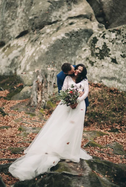 Gorgeous bride, groom kissing and hugging near the cliffs with stunning views — Stock Photo, Image