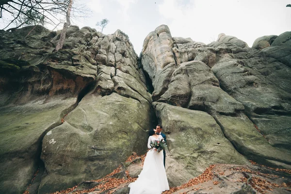 Preciosa novia, novio besándose y abrazándose cerca de los acantilados con impresionantes vistas —  Fotos de Stock
