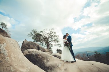 Muhteşem gelin, damat öpüşme ve sarılma Gösterim çarpıcı uçurum yakın: